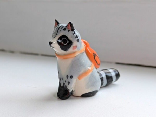 adorable raccoon figurine with a cute backpack porcelain