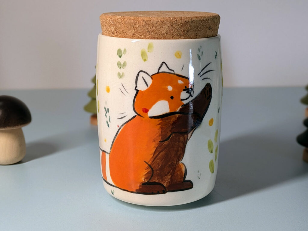 lidded vessel for loose leaf tea or ground coffee, illustrated with a red panda