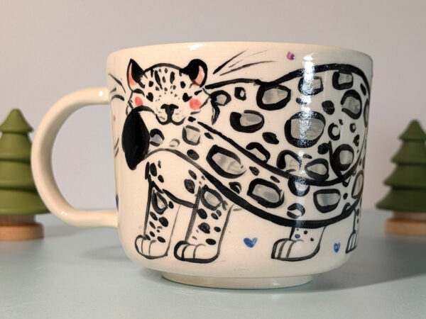 snow leopard tail in mouth mug