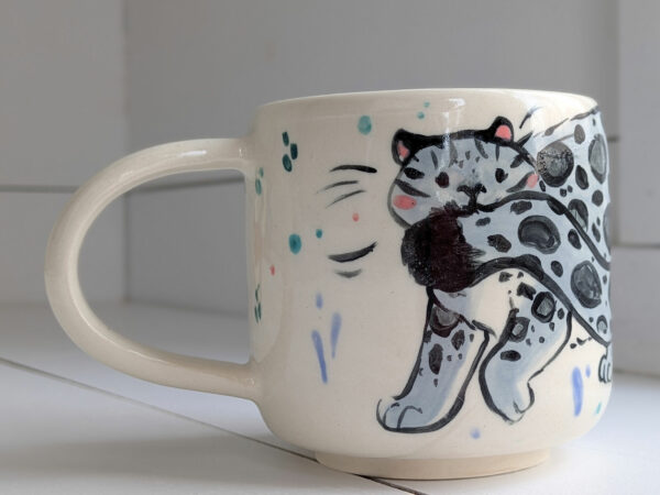 snow leopard tail in mouth mug