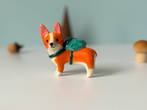 adorable corgi figurine in a backpack