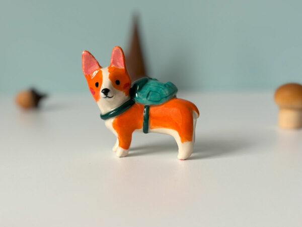 adorable corgi figurine in a backpack