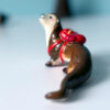 adorable porcelain otter figurine with a backpack