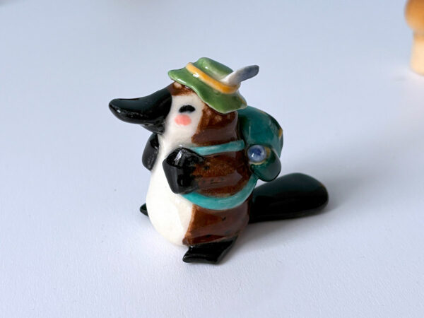 adorable platypus figurine with a backpack and feathered hat