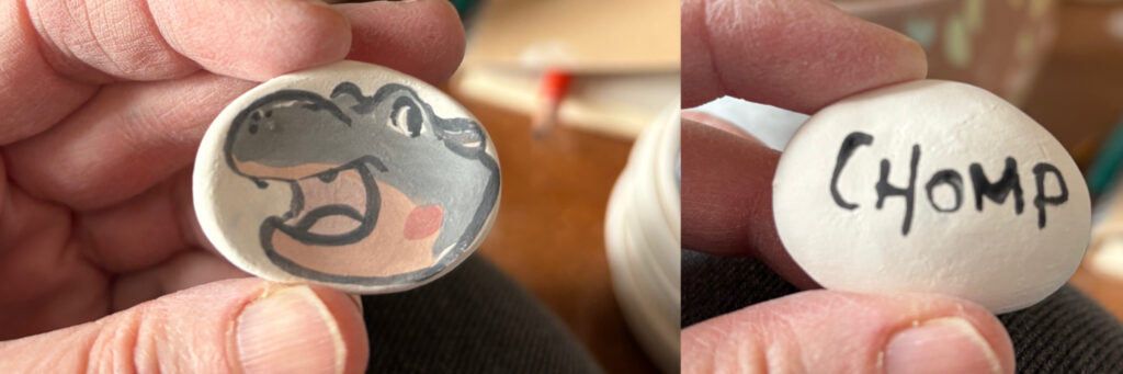 ceramic worry stone with a little hippo on one side and Chomp written on the other side 
