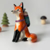 adorable figurine of a fox in a backpack with a passenger